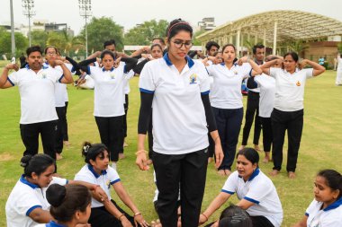Yeni Delhi, Hindistan, 21 Haziran 2023 - Uluslararası Yoga Günü 'nde Delhi' deki Yamuna Spor Kompleksi 'nde grup Yoga egzersiz oturumu, kriket stadyumunda yoga derslerine katılan büyük bir grup yetişkin