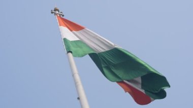 India flag flying high at Connaught Place with pride in blue sky, India flag fluttering, Indian Flag on Independence Day and Republic Day of India, tilt up shot, Waving Indian flag, Har Ghar Tiranga