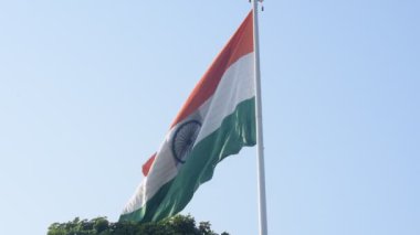 India flag flying high at Connaught Place with pride in blue sky, India flag fluttering, Indian Flag on Independence Day and Republic Day of India, tilt up shot, Waving Indian flag, Har Ghar Tiranga