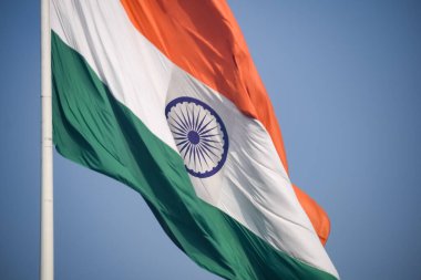 India flag flying high at Connaught Place with pride in blue sky, India flag fluttering, Indian Flag on Independence Day and Republic Day of India, tilt up shot, Waving Indian flag, Har Ghar Tiranga