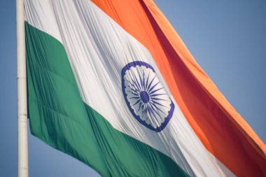 India flag flying high at Connaught Place with pride in blue sky, India flag fluttering, Indian Flag on Independence Day and Republic Day of India, tilt up shot, Waving Indian flag, Har Ghar Tiranga