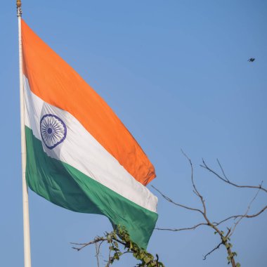 India flag flying high at Connaught Place with pride in blue sky, India flag fluttering, Indian Flag on Independence Day and Republic Day of India, tilt up shot, Waving Indian flag, Har Ghar Tiranga