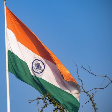 India flag flying high at Connaught Place with pride in blue sky, India flag fluttering, Indian Flag on Independence Day and Republic Day of India, tilt up shot, Waving Indian flag, Har Ghar Tiranga