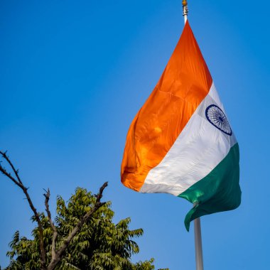 India flag flying high at Connaught Place with pride in blue sky, India flag fluttering, Indian Flag on Independence Day and Republic Day of India, tilt up shot, Waving Indian flag, Har Ghar Tiranga