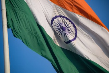India flag flying high at Connaught Place with pride in blue sky, India flag fluttering, Indian Flag on Independence Day and Republic Day of India, tilt up shot, Waving Indian flag, Har Ghar Tiranga
