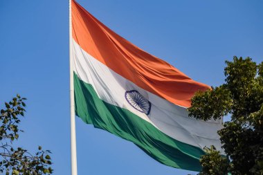 India flag flying high at Connaught Place with pride in blue sky, India flag fluttering, Indian Flag on Independence Day and Republic Day of India, tilt up shot, Waving Indian flag, Har Ghar Tiranga