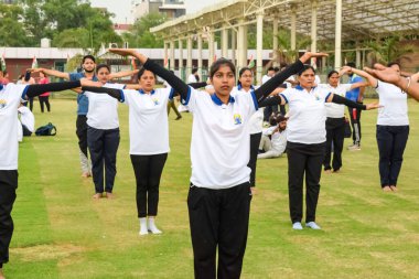 Yeni Delhi, Hindistan, 21 Haziran 2023 - Uluslararası Yoga Günü 'nde Delhi' deki Yamuna Spor Kompleksi 'nde grup Yoga egzersiz oturumu, kriket stadyumunda yoga derslerine katılan büyük bir grup yetişkin