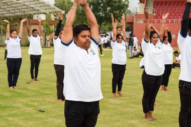 Yeni Delhi, Hindistan, 21 Haziran 2023 - Uluslararası Yoga Günü 'nde Delhi' deki Yamuna Spor Kompleksi 'nde grup Yoga egzersiz oturumu, kriket stadyumunda yoga derslerine katılan büyük bir grup yetişkin