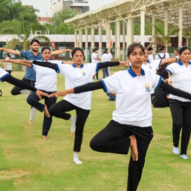 Yeni Delhi, Hindistan, 21 Haziran 2023 - Uluslararası Yoga Günü 'nde Delhi' deki Yamuna Spor Kompleksi 'nde grup Yoga egzersiz oturumu, kriket stadyumunda yoga derslerine katılan büyük bir grup yetişkin
