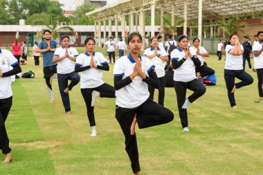 Yeni Delhi, Hindistan, 21 Haziran 2023 - Uluslararası Yoga Günü 'nde Delhi' deki Yamuna Spor Kompleksi 'nde grup Yoga egzersiz oturumu, kriket stadyumunda yoga derslerine katılan büyük bir grup yetişkin
