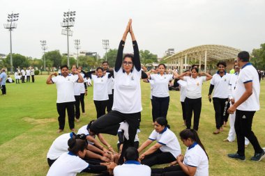 Yeni Delhi, Hindistan, 21 Haziran 2023 - Uluslararası Yoga Günü 'nde Delhi' deki Yamuna Spor Kompleksi 'nde grup Yoga egzersiz oturumu, kriket stadyumunda yoga derslerine katılan büyük bir grup yetişkin