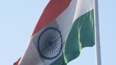 India flag flying high at Connaught Place with pride in blue sky, India flag fluttering, Indian Flag on Independence Day and Republic Day of India, tilt up shot, Waving Indian flag, Har Ghar Tiranga