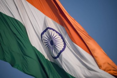 India flag flying high at Connaught Place with pride in blue sky, India flag fluttering, Indian Flag on Independence Day and Republic Day of India, tilt up shot, Waving Indian flag, Har Ghar Tiranga