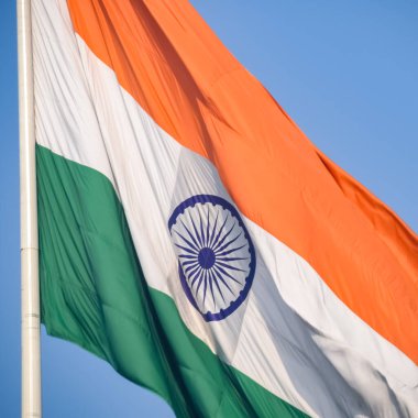 India flag flying high at Connaught Place with pride in blue sky, India flag fluttering, Indian Flag on Independence Day and Republic Day of India, tilt up shot, Waving Indian flag, Har Ghar Tiranga