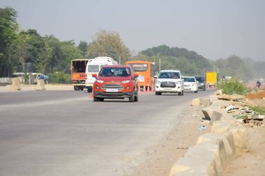 Yeni Delhi, Hindistan - 16 Nisan 2023 - Indra Gandhi Uluslararası Havalimanı yakınlarındaki ana yoldan geçen araçların görüntüsü