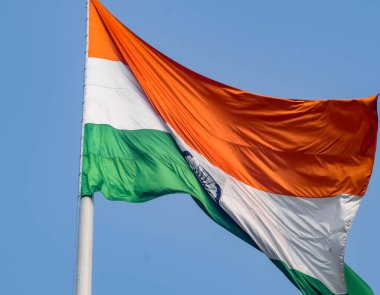 India flag flying high at Connaught Place with pride in blue sky, India flag fluttering, Indian Flag on Independence Day and Republic Day of India, tilt up shot, Waving Indian flag, Har Ghar Tiranga