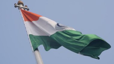 India flag flying high at Connaught Place with pride in blue sky, India flag fluttering, Indian Flag on Independence Day and Republic Day of India, tilt up shot, Waving Indian flag, Har Ghar Tiranga