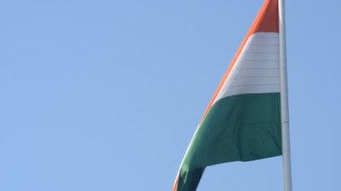 India flag flying high at Connaught Place with pride in blue sky, India flag fluttering, Indian Flag on Independence Day and Republic Day of India, tilt up shot, Waving Indian flag, Har Ghar Tiranga