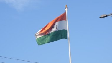 India flag flying high at Connaught Place with pride in blue sky, India flag fluttering, Indian Flag on Independence Day and Republic Day of India, tilt up shot, Waving Indian flag, Har Ghar Tiranga