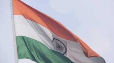 India flag flying high at Connaught Place with pride in blue sky, India flag fluttering, Indian Flag on Independence Day and Republic Day of India, tilt up shot, Waving Indian flag, Har Ghar Tiranga