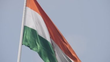 India flag flying high at Connaught Place with pride in blue sky, India flag fluttering, Indian Flag on Independence Day and Republic Day of India, tilt up shot, Waving Indian flag, Har Ghar Tiranga