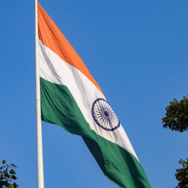 India flag flying high at Connaught Place with pride in blue sky, India flag fluttering, Indian Flag on Independence Day and Republic Day of India, tilt up shot, Waving Indian flag, Har Ghar Tiranga