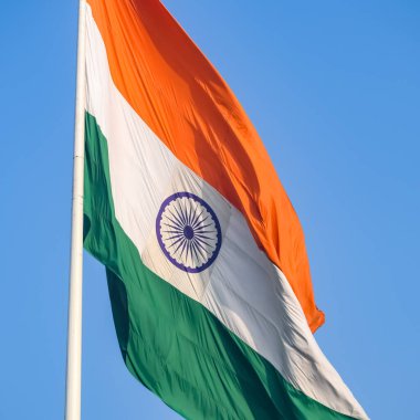 India flag flying high at Connaught Place with pride in blue sky, India flag fluttering, Indian Flag on Independence Day and Republic Day of India, tilt up shot, Waving Indian flag, Har Ghar Tiranga