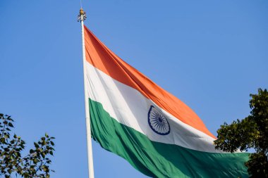 India flag flying high at Connaught Place with pride in blue sky, India flag fluttering, Indian Flag on Independence Day and Republic Day of India, tilt up shot, Waving Indian flag, Har Ghar Tiranga