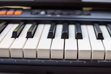 Piyano tuşlarına yakın çekim. Piyano siyah ve beyaz tuşlar ve piyano klavye müzik aleti güneşli bir günde ev balkonuna yerleştirildi.