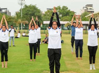 Yeni Delhi, Hindistan, 21 Haziran 2023 - Uluslararası Yoga Günü 'nde Delhi' deki Yamuna Spor Kompleksi 'nde grup Yoga egzersiz oturumu, kriket stadyumunda yoga derslerine katılan büyük bir grup yetişkin