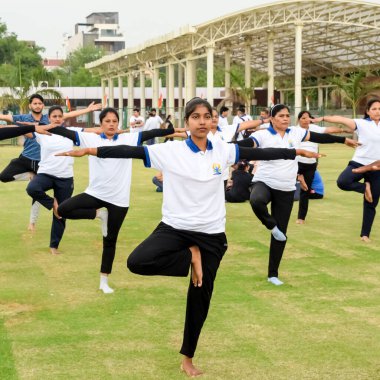 Yeni Delhi, Hindistan, 21 Haziran 2023 - Uluslararası Yoga Günü 'nde Delhi' deki Yamuna Spor Kompleksi 'nde grup Yoga egzersiz oturumu, kriket stadyumunda yoga derslerine katılan büyük bir grup yetişkin