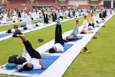 Yeni Delhi, Hindistan, 21 Haziran 2023 - Uluslararası Yoga Günü 'nde Delhi' deki Yamuna Spor Kompleksi 'nde grup Yoga egzersiz oturumu, kriket stadyumunda yoga derslerine katılan büyük bir grup yetişkin