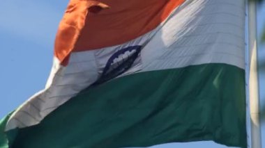 India flag flying high at Connaught Place with pride in blue sky, India flag fluttering, Indian Flag on Independence Day and Republic Day of India, tilt up shot, Waving Indian flag, Har Ghar Tiranga