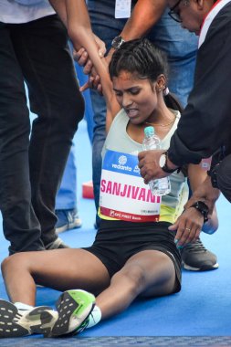 Yeni Delhi, Hindistan - 16 Ekim 2022 - Bitmek üzere olan maraton katılımcılarının bitiş çizgisini geçmek üzere olan Delhi Yarı Maratonu 2022