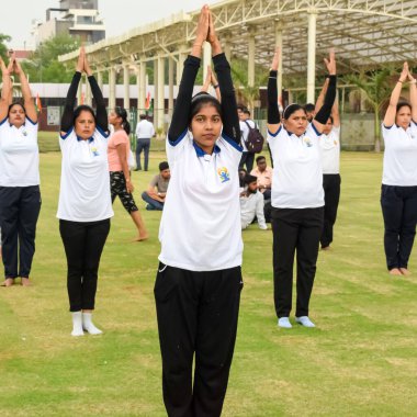 Yeni Delhi, Hindistan, 21 Haziran 2023 - Uluslararası Yoga Günü 'nde Delhi' deki Yamuna Spor Kompleksi 'nde grup Yoga egzersiz oturumu, kriket stadyumunda yoga derslerine katılan büyük bir grup yetişkin