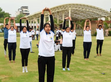 Yeni Delhi, Hindistan, 21 Haziran 2023 - Uluslararası Yoga Günü 'nde Delhi' deki Yamuna Spor Kompleksi 'nde grup Yoga egzersiz oturumu, kriket stadyumunda yoga derslerine katılan büyük bir grup yetişkin