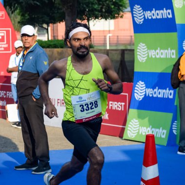 Yeni Delhi, Hindistan - 16 Ekim 2022 - Bitmek üzere olan maraton katılımcılarının bitiş çizgisini geçmek üzere olan Delhi Yarı Maratonu 2022