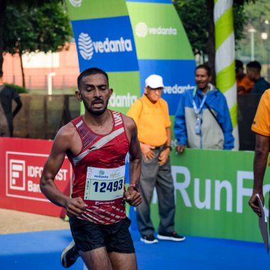 Yeni Delhi, Hindistan - 16 Ekim 2022 - Bitmek üzere olan maraton katılımcılarının bitiş çizgisini geçmek üzere olan Delhi Yarı Maratonu 2022