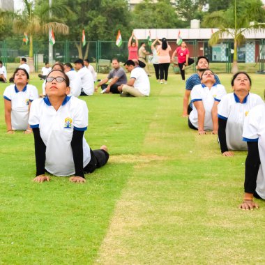 Yeni Delhi, Hindistan, 21 Haziran 2023 - Uluslararası Yoga Günü 'nde Delhi' deki Yamuna Spor Kompleksi 'nde grup Yoga egzersiz oturumu, kriket stadyumunda yoga derslerine katılan büyük bir grup yetişkin