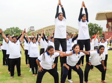 Yeni Delhi, Hindistan, 21 Haziran 2023 - Uluslararası Yoga Günü 'nde Delhi' deki Yamuna Spor Kompleksi 'nde grup Yoga egzersiz oturumu, kriket stadyumunda yoga derslerine katılan büyük bir grup yetişkin