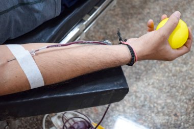 Blood donor at Blood donation camp held with a bouncy ball holding in hand at Balaji Temple, Vivek Vihar, Delhi, India, Image for World blood donor day on June 14 every year, Blood Donation Camp