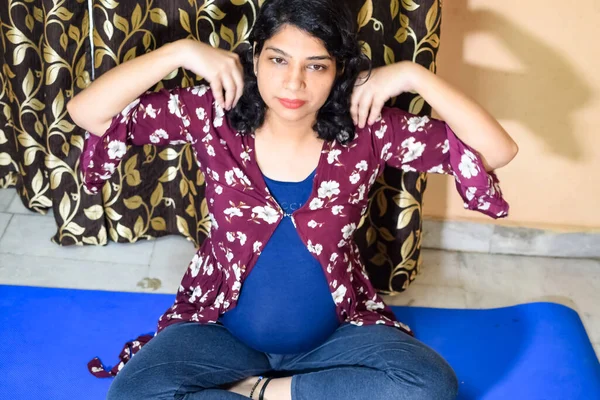 Pregnant woman doing Pregnancy yoga pose comfortable at home with belly, Pregnant woman practicing simple yoga steps at home, Pregnancy yoga and fitness poses