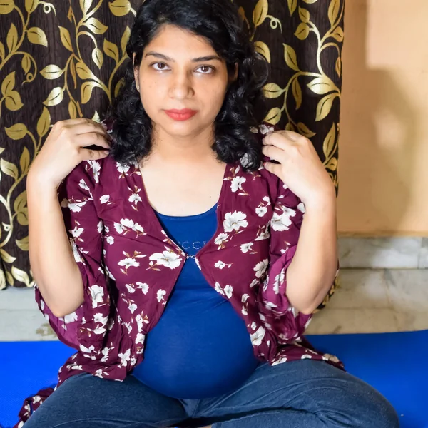 Pregnant woman doing Pregnancy yoga pose comfortable at home with belly, Pregnant woman practicing simple yoga steps at home, Pregnancy yoga and fitness poses