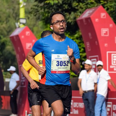 Yeni Delhi, Hindistan - 16 Ekim 2022 - Bitmek üzere olan maraton katılımcılarının bitiş çizgisini geçmek üzere olan Delhi Yarı Maratonu 2022