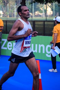 Yeni Delhi, Hindistan - 16 Ekim 2022 - Bitmek üzere olan maraton katılımcılarının bitiş çizgisini geçmek üzere olan Delhi Yarı Maratonu 2022