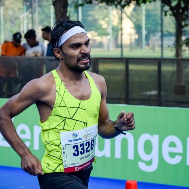 Yeni Delhi, Hindistan - 16 Ekim 2022 - Bitmek üzere olan maraton katılımcılarının bitiş çizgisini geçmek üzere olan Delhi Yarı Maratonu 2022