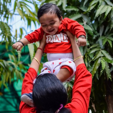 Sosyete parkında bebeğini taşıyan bir anne. Mutlu bir annenin parlak portresi. Çocuğu elinde tutuyor. Anne, 9 aylık oğluna sarılıyor..