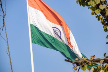 India flag flying high at Connaught Place with pride in blue sky, India flag fluttering, Indian Flag on Independence Day and Republic Day of India, tilt up shot, Waving Indian flag, Har Ghar Tiranga