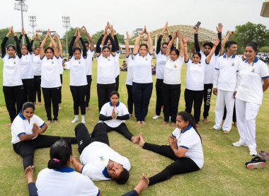 Yeni Delhi, Hindistan, 21 Haziran 2023 - Uluslararası Yoga Günü 'nde Delhi' deki Yamuna Spor Kompleksi 'nde grup Yoga egzersiz oturumu, kriket stadyumunda yoga derslerine katılan büyük bir grup yetişkin