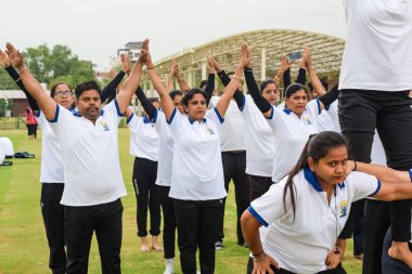 Yeni Delhi, Hindistan, 21 Haziran 2023 - Uluslararası Yoga Günü 'nde Delhi' deki Yamuna Spor Kompleksi 'nde grup Yoga egzersiz oturumu, kriket stadyumunda yoga derslerine katılan büyük bir grup yetişkin